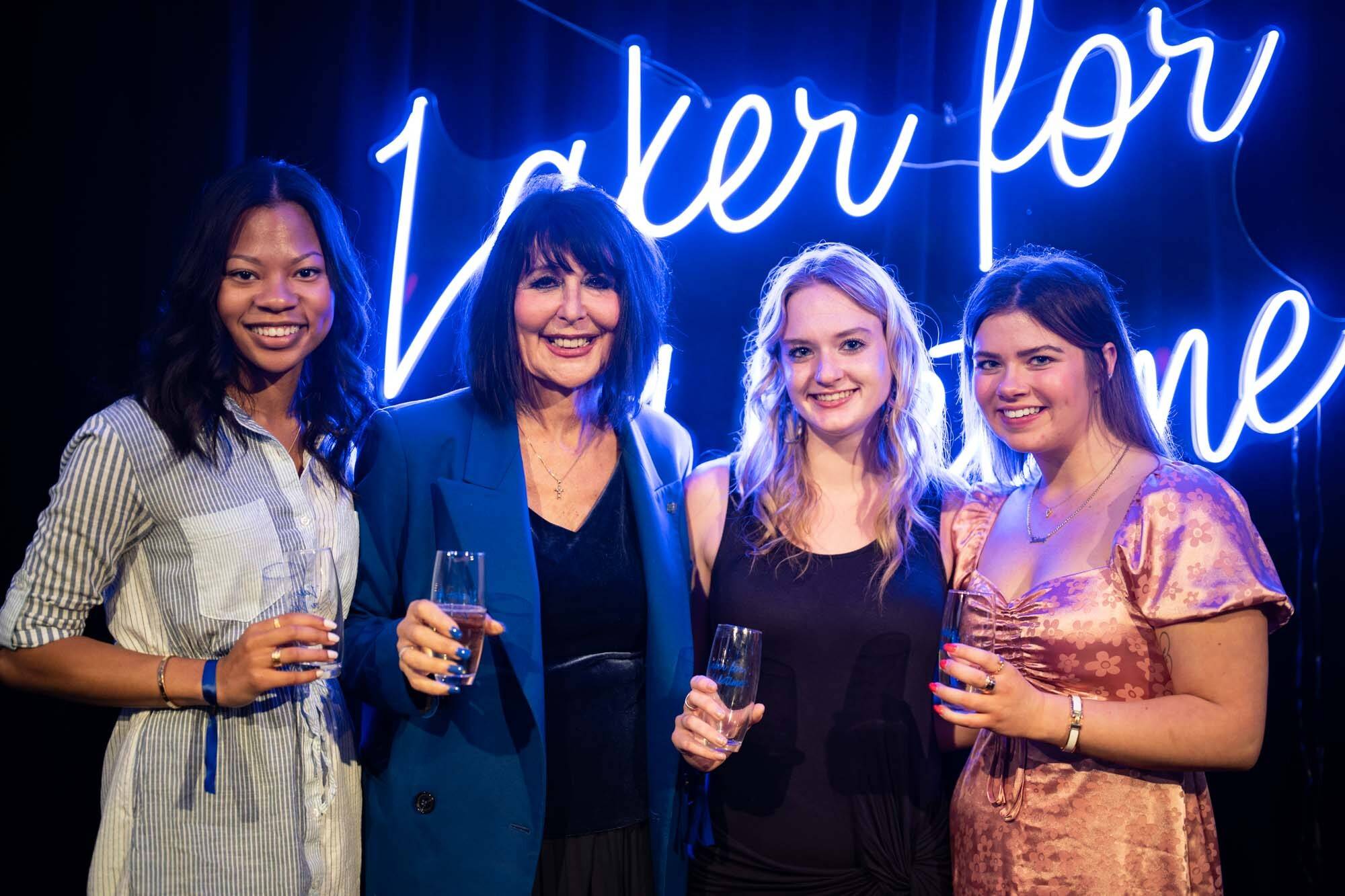 Four graduates pose for a photo at a Toast event